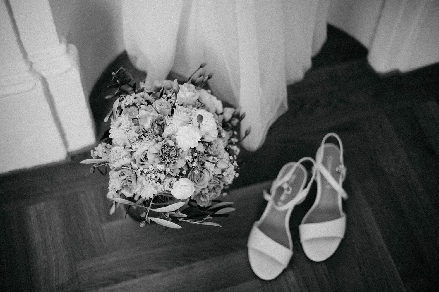 Black and white wedding detail photos showing rings, flowers, shoes, and accessories arranged artistically.