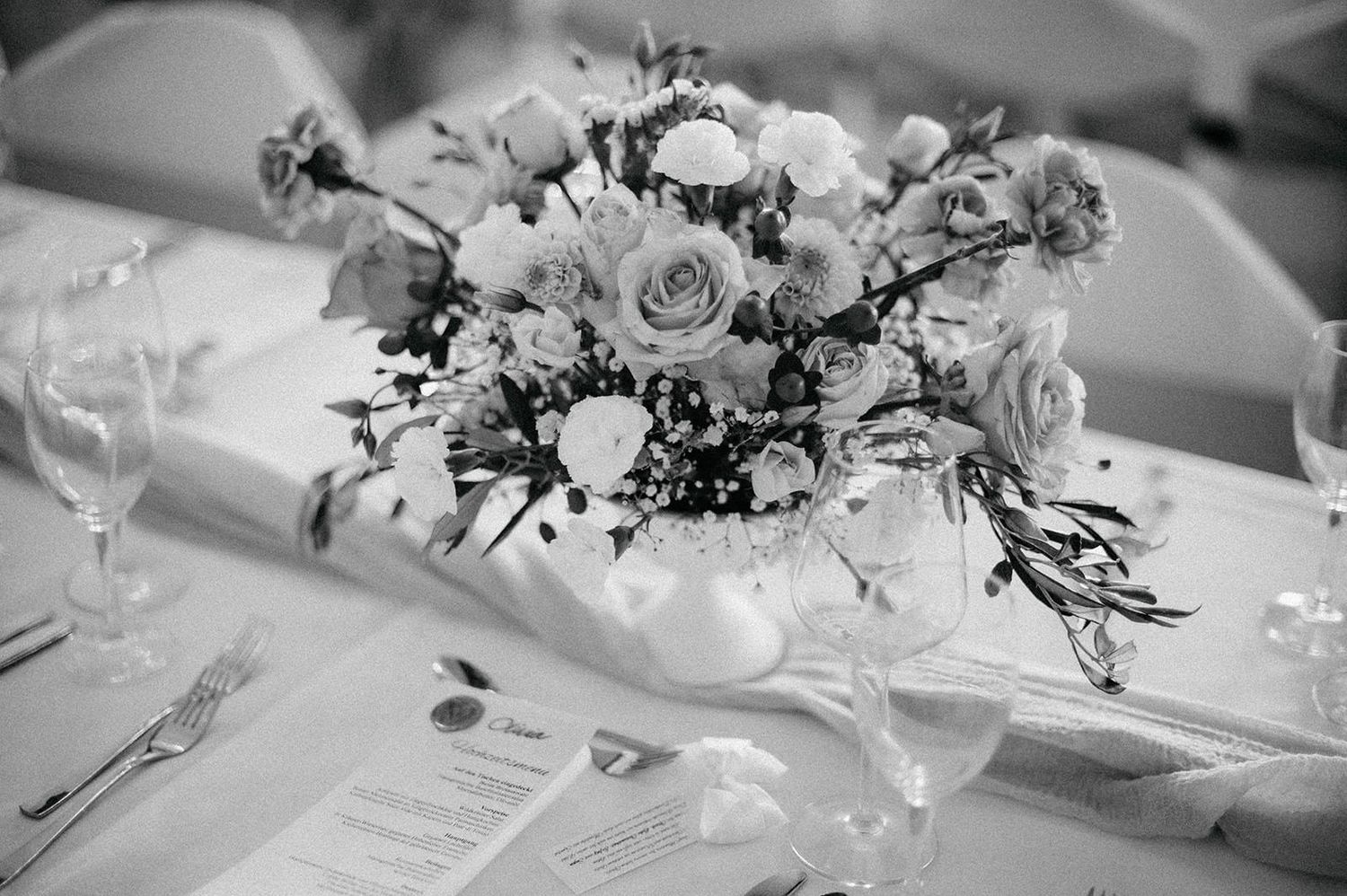 Black and white wedding reception table settings with elegant floral centerpieces and crystal glassware.