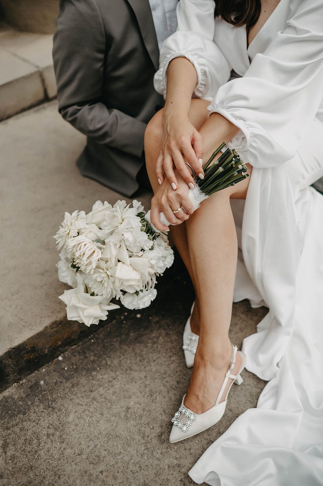 Close-up shots of a bride's white heels and dress hem during a wedding ceremony.