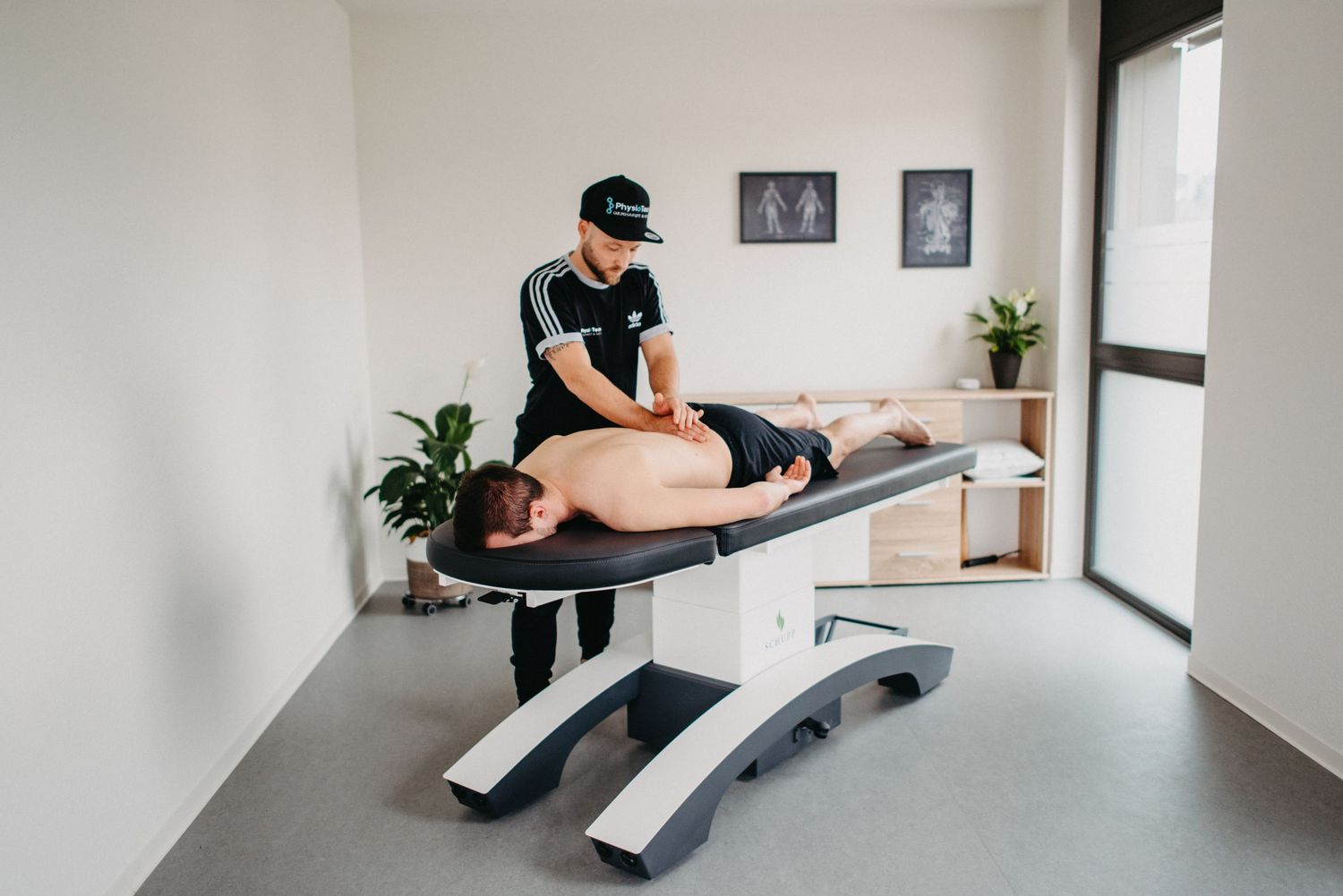 Professional massage therapy session in a modern wellness clinic with plants and natural light.