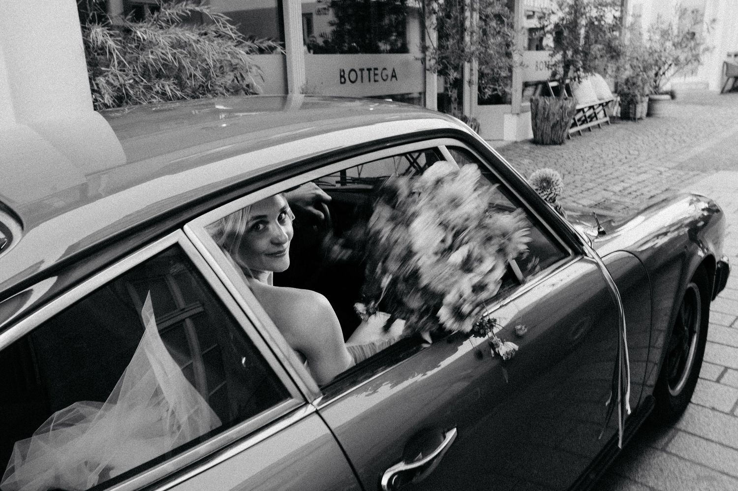 A black and white photo montage shows multiple vintage cars with passengers sitting inside them.