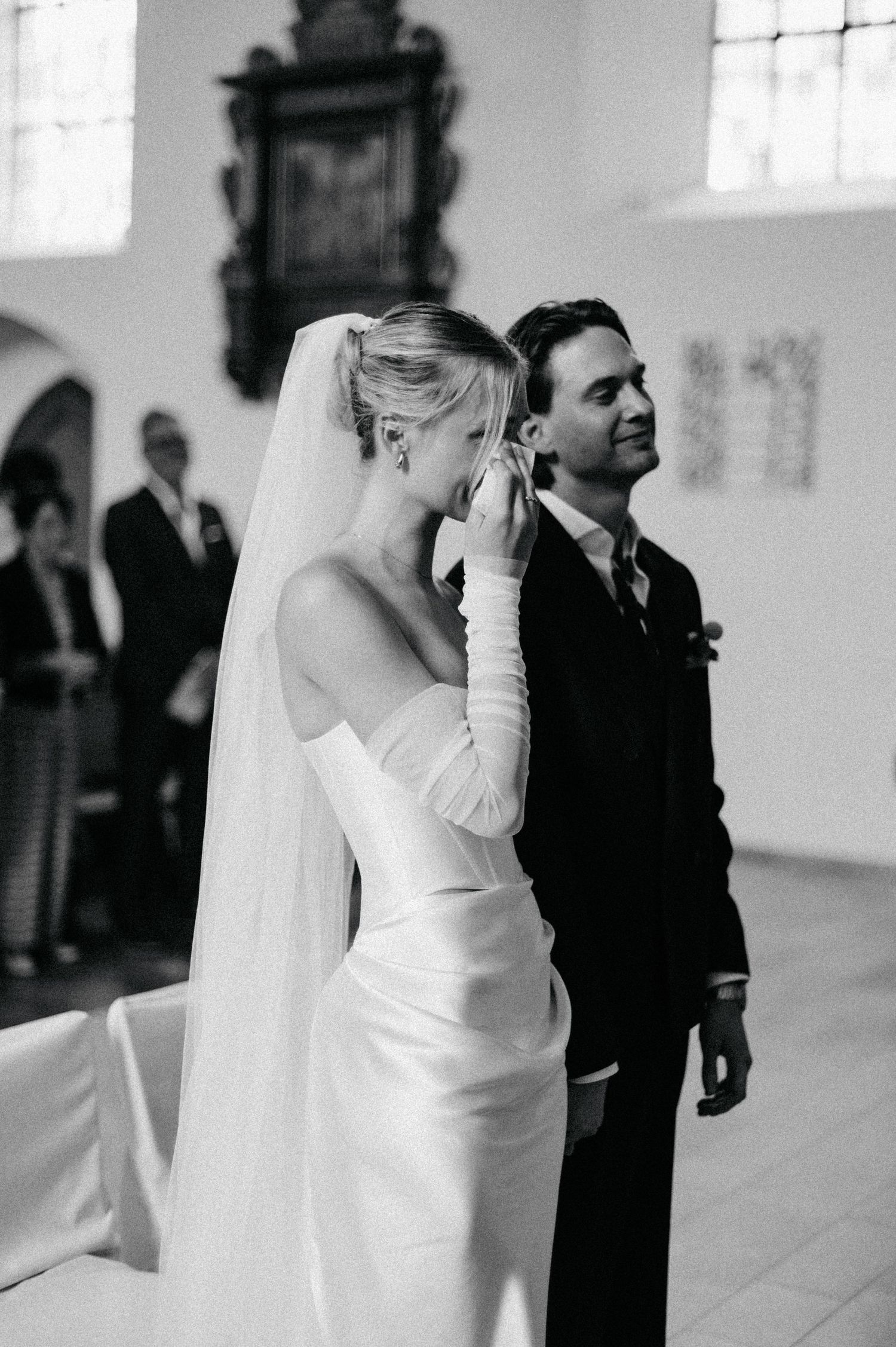 Black and white wedding photograph series showing intimate moments between a bride in white dress and groom in dark suit.