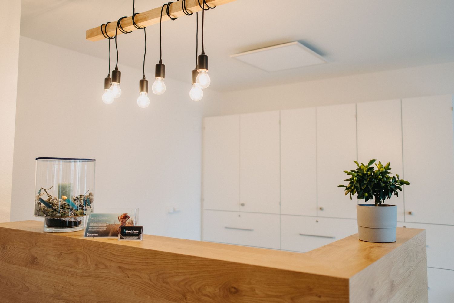 Modern kitchen interior with hanging pendant lights and wooden counter detail.