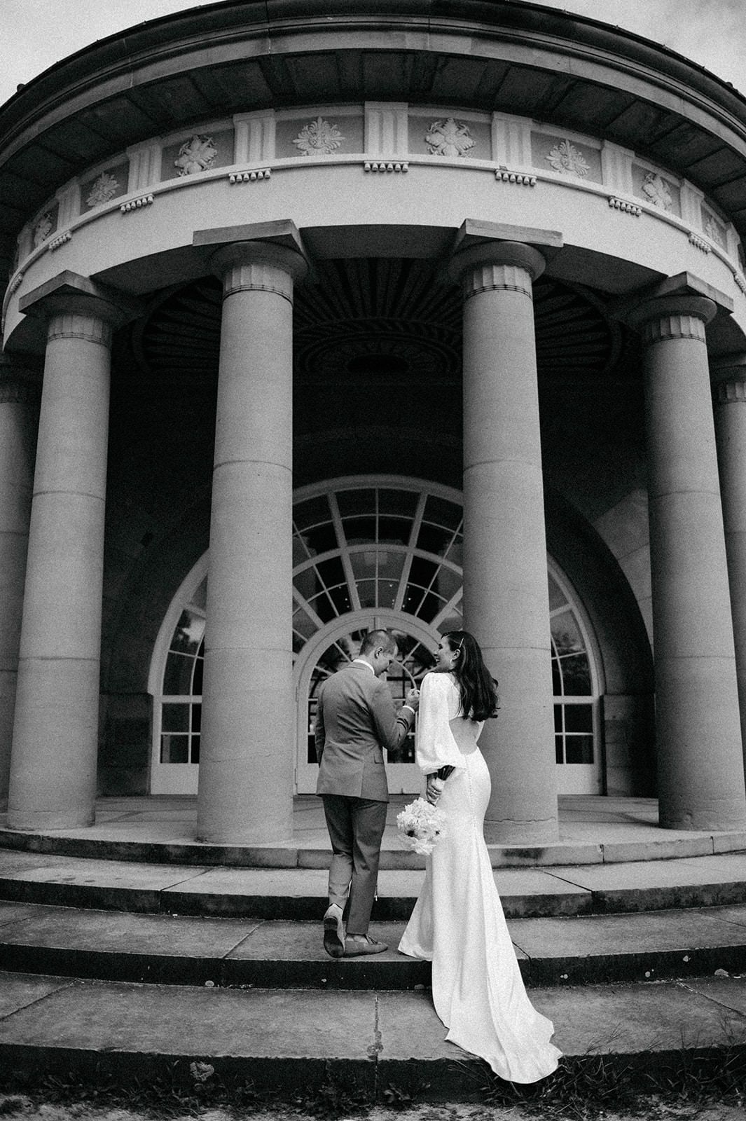 A panoramic sequence of black and white photos showing movement across a classical columned building entrance.
