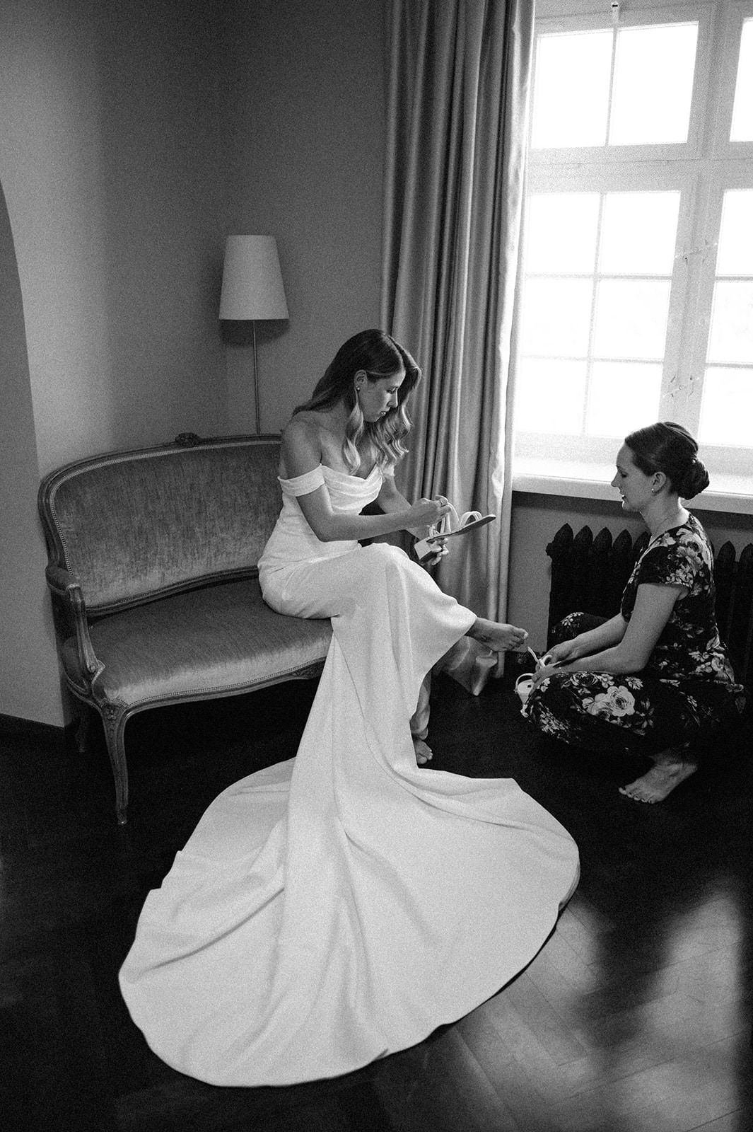 Black and white photos of a bride in flowing dress twirling and posing on a vintage couch.