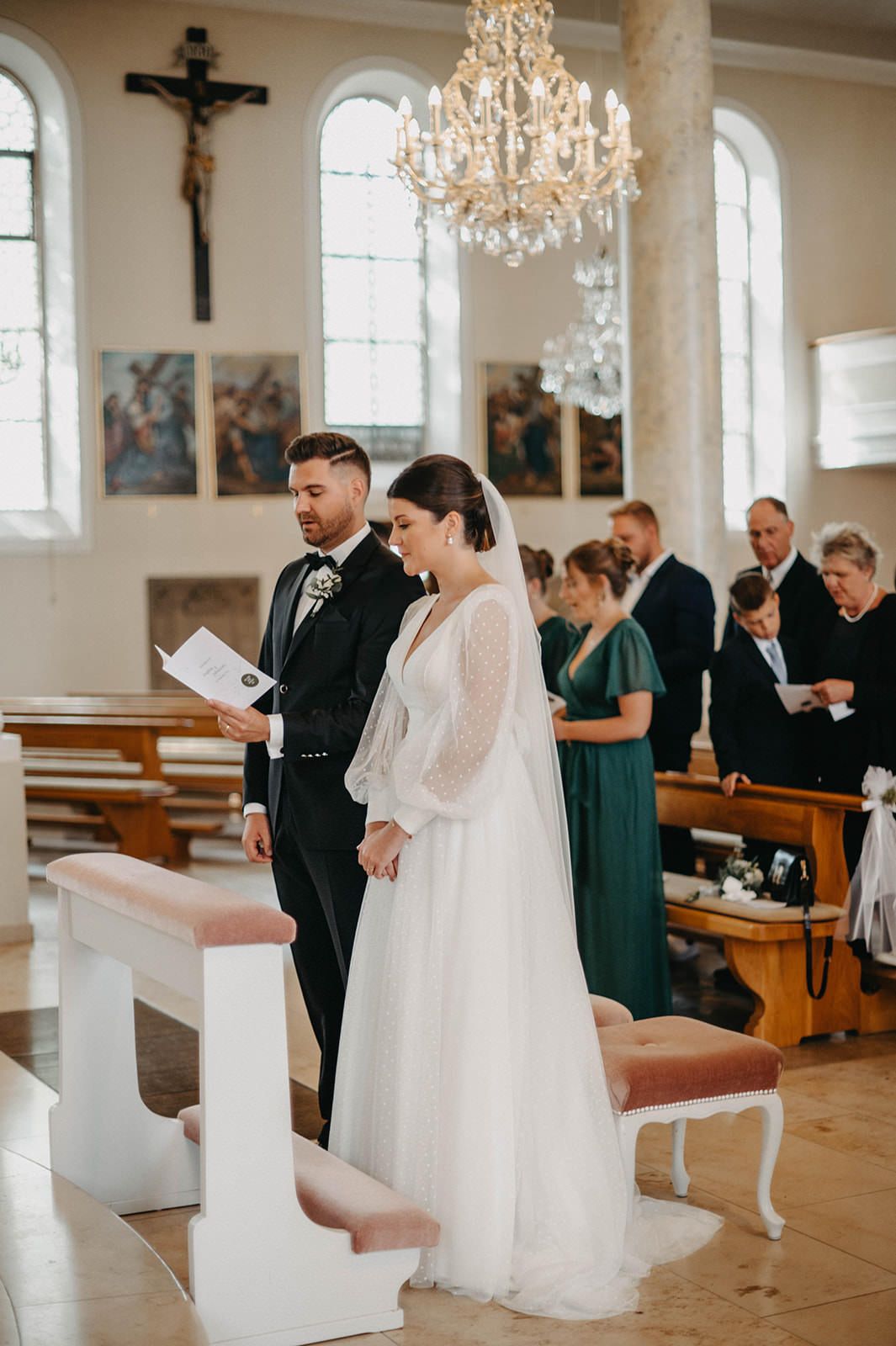 Elegant church wedding ceremony with crystal chandeliers and wooden pews showing three moments during the service.