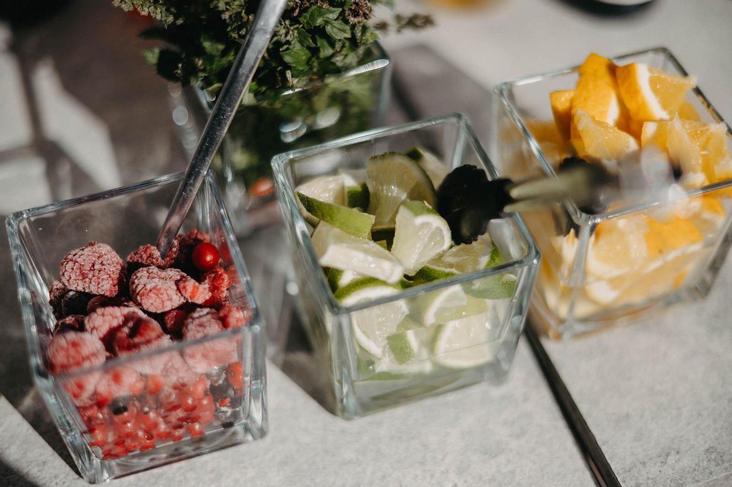 Small glass bowls filled with various colorful ingredients and garnishes arranged in a row on a table.
