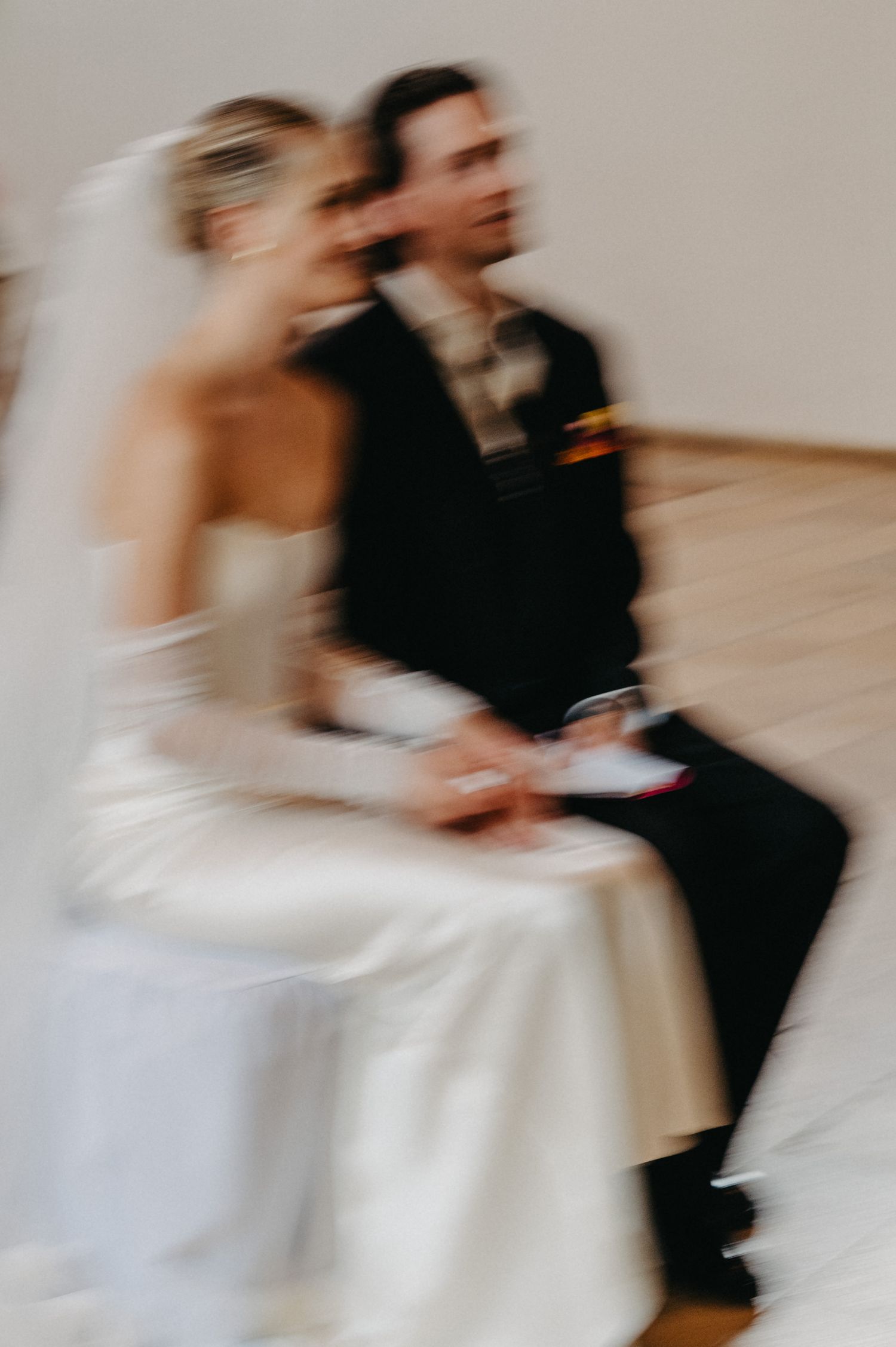 Motion-blurred sequence of a bride and groom dancing together in formal wedding attire.