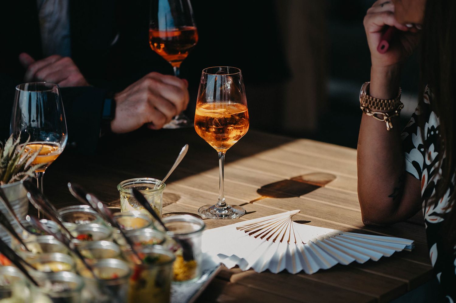 Elegant cocktails and drinks being served at a dimly lit bar with warm ambient lighting.