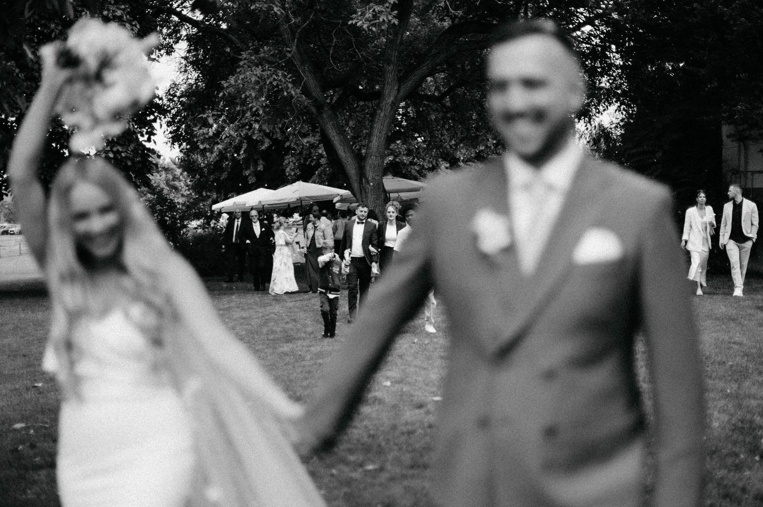 Candid wedding moments captured in black and white during an outdoor celebration.