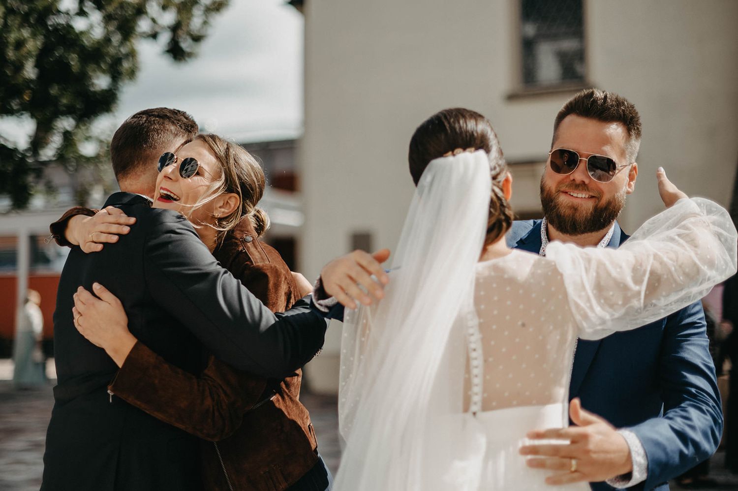 Emotional embraces and greetings between wedding guests and attendees at an outdoor celebration.