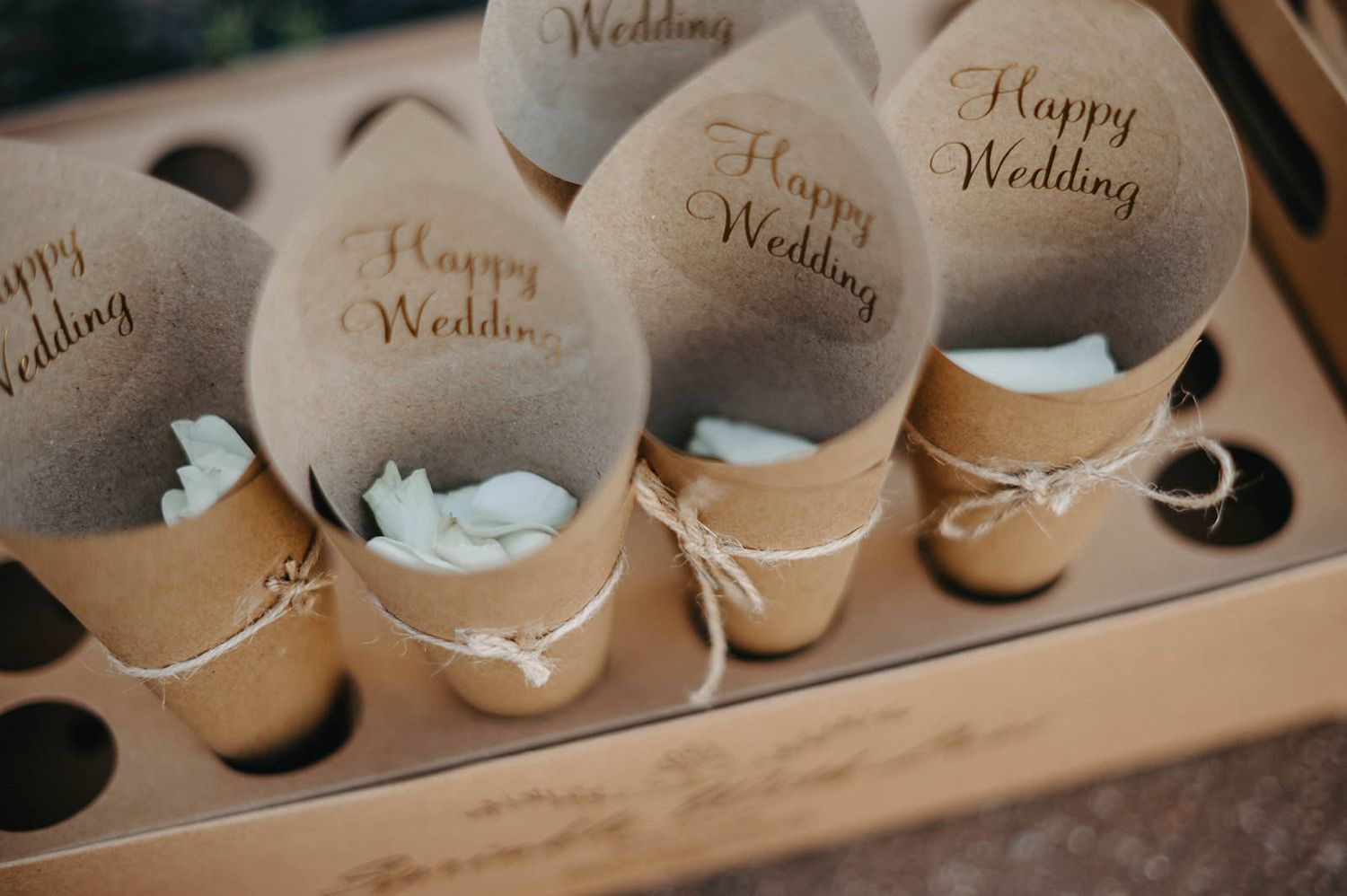Row of elegant beige wedding shoes arranged with decorative tags and labels on display.