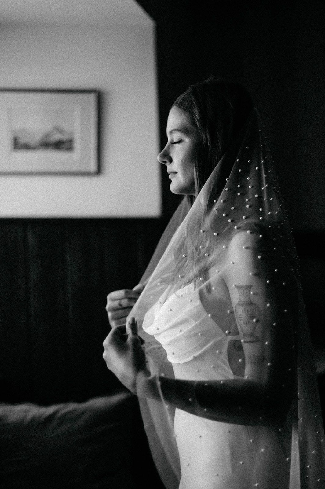 A sequence of black and white photos showing a bride adjusting her delicate dotted veil in profile view.