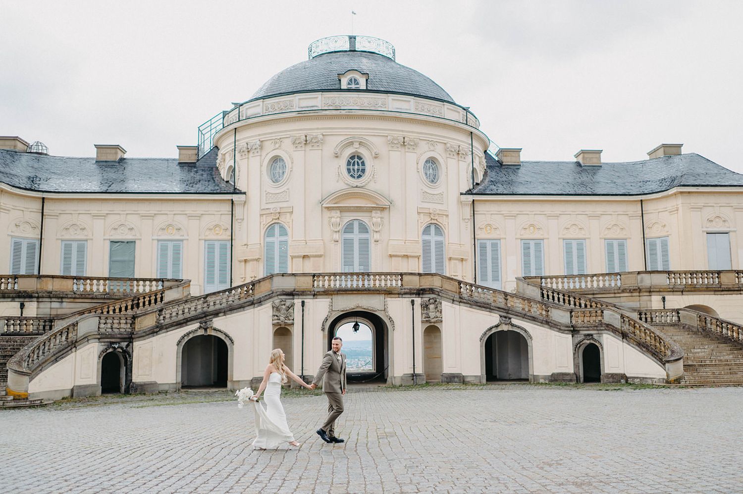 Panoramic view of a grand historic palace with domed roof and symmetrical architecture.