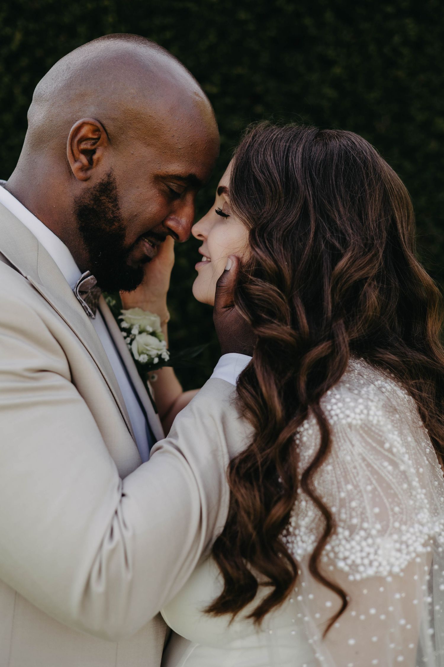 Intimate wedding couple portraits showing tender moments against a dark background.