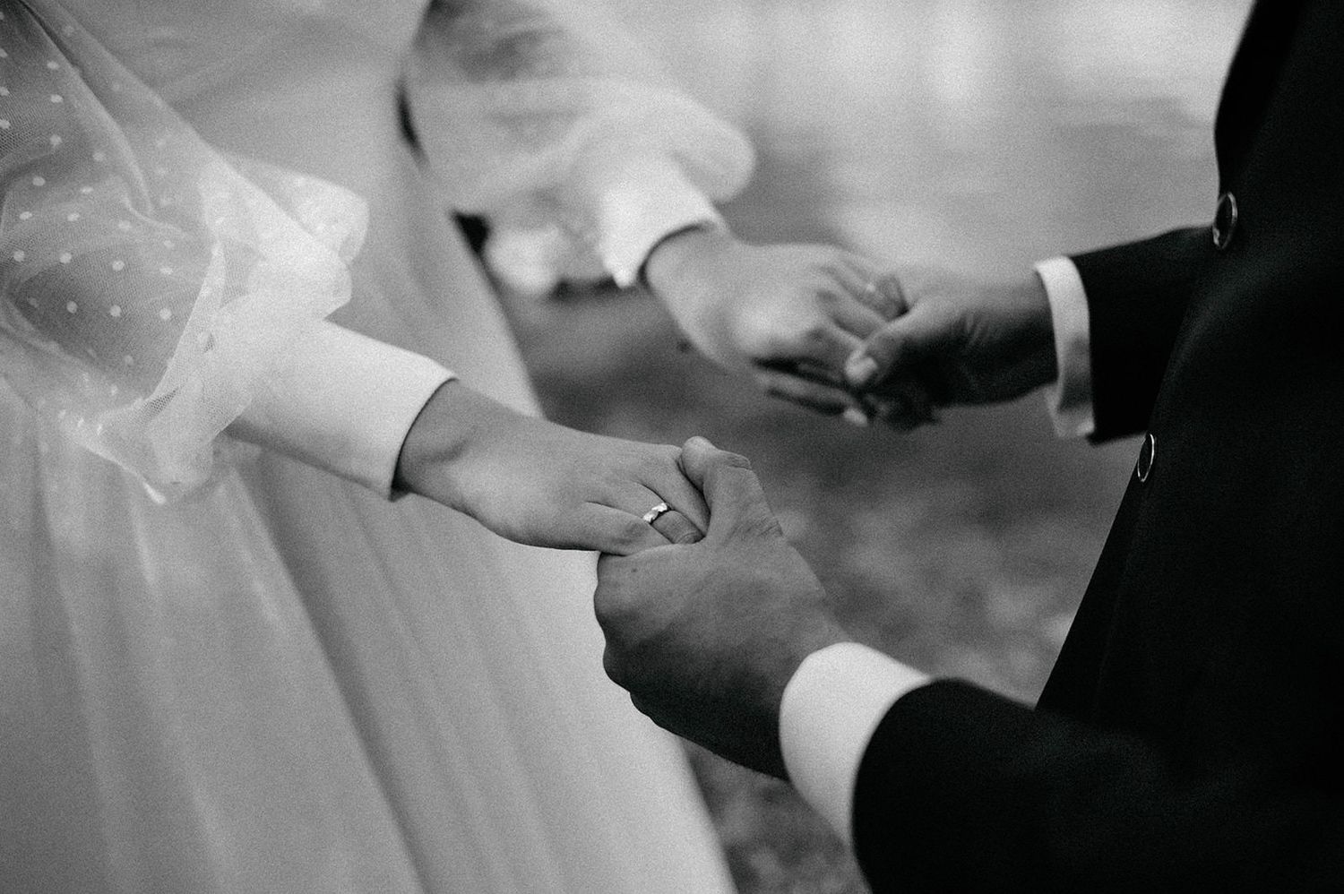 A series of black and white photos showing hands exchanging wedding rings during a marriage ceremony.