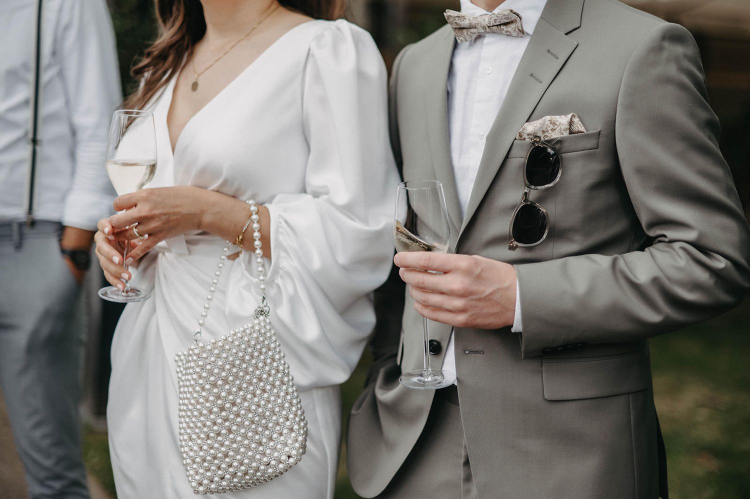 Elegant wedding reception scene with guests in formal attire holding champagne glasses during a toast.