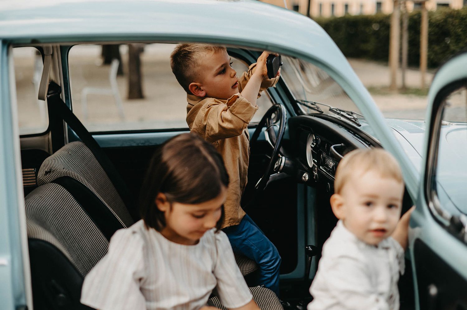Family members of different generations sit together in a car interior during a sunny day.