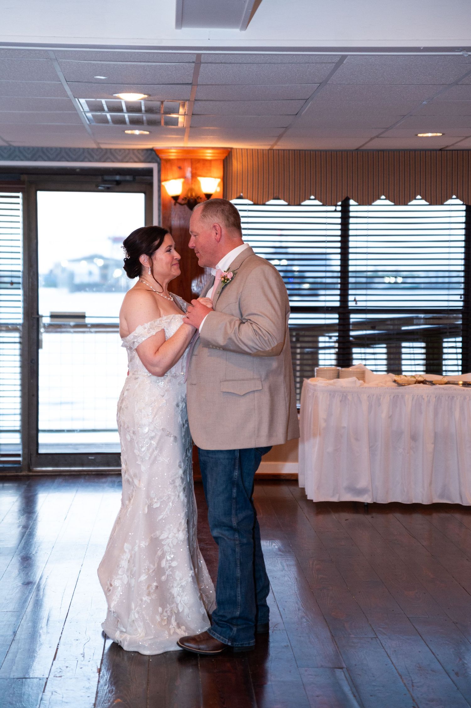 Bride and groom sharing first dance in elegant waterfront wedding reception venue.