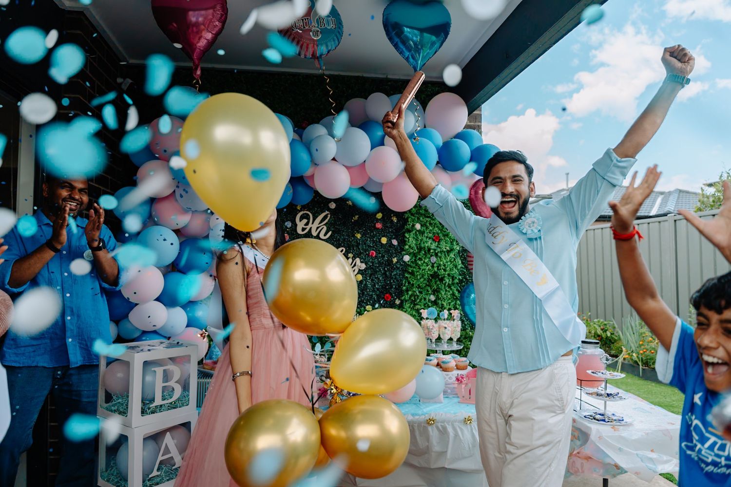 Festive celebration with blue and pink balloon arrangements and decorative party elements.