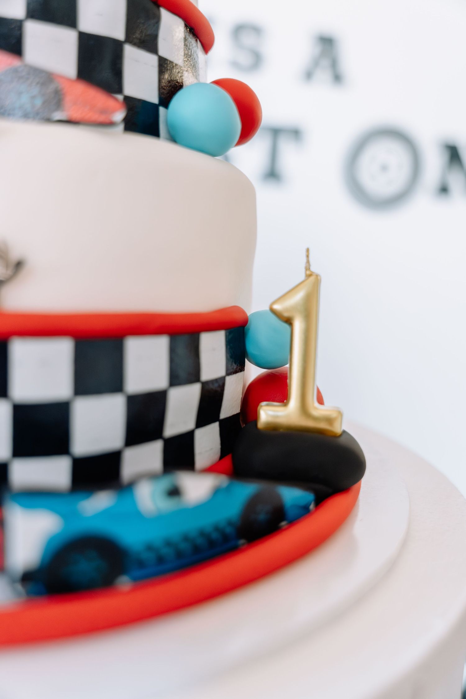 Close-up detail of a black and white checkered racing-themed cake with red trim and blue accents.