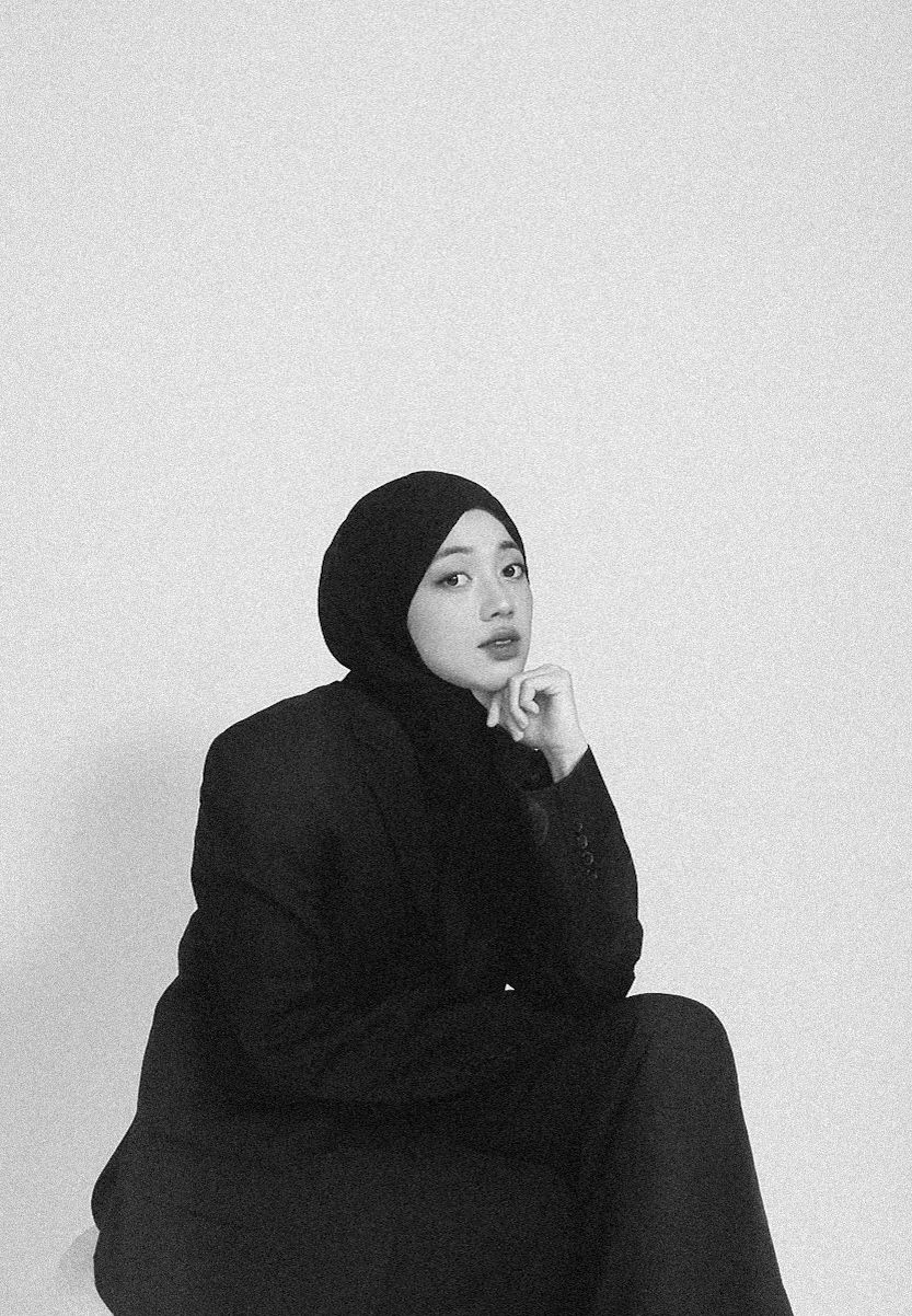Artistic black and white portrait series showing figure in black hijab against white background.