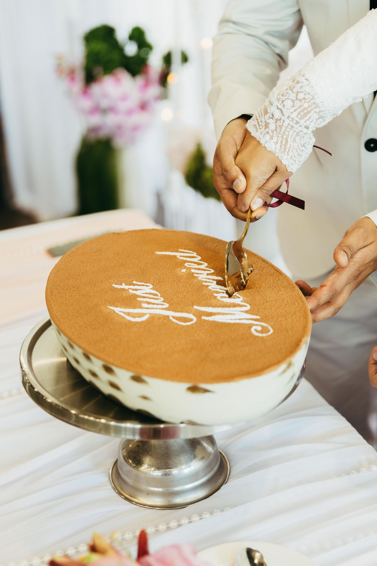 Bride and groom cutting wedding cake inscribed with Just Married at elegant reception.