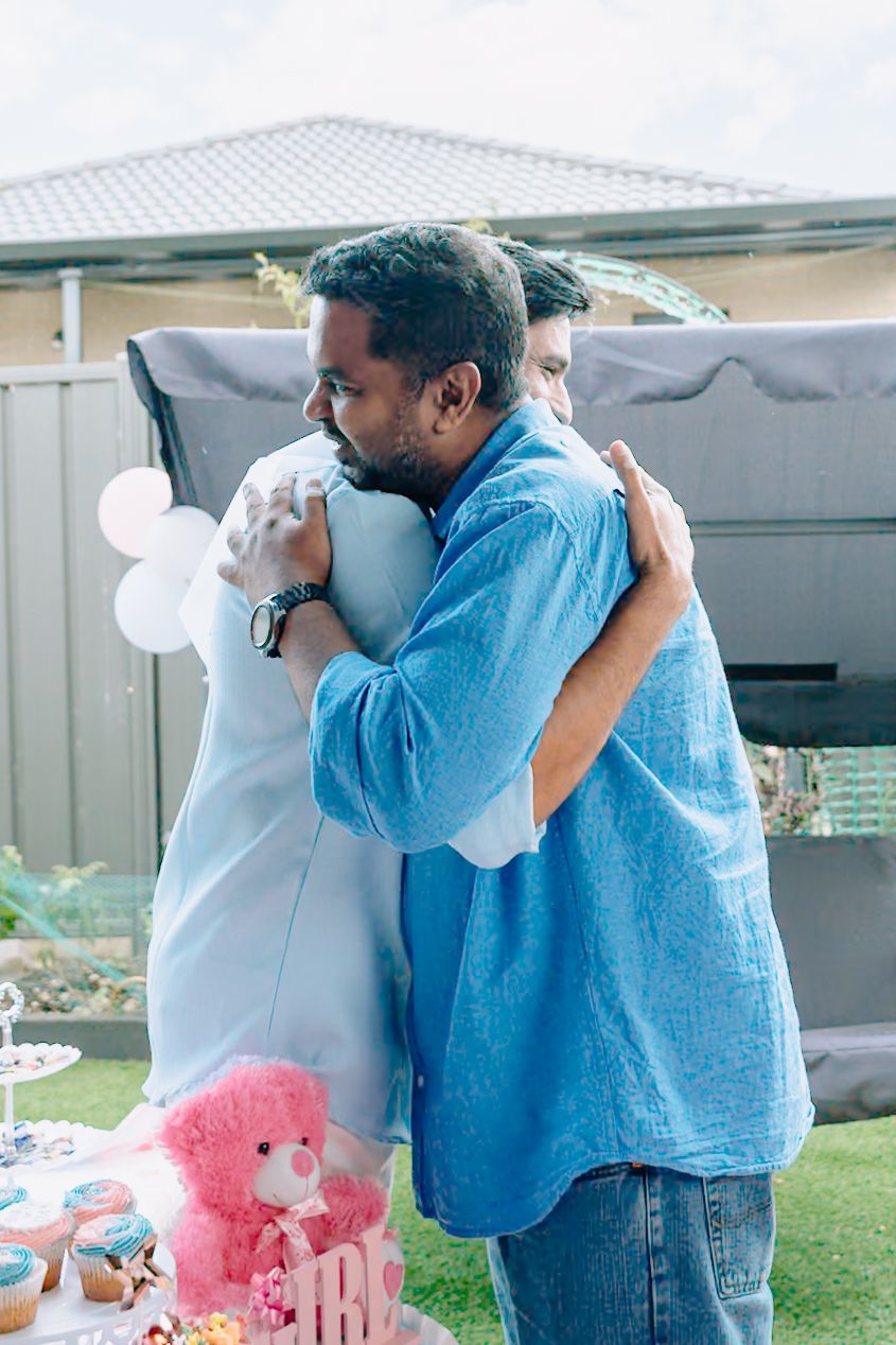 Three sequential images show a heartfelt embrace between two people wearing blue and white clothing outdoors.