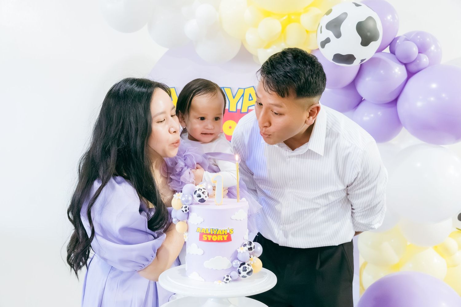 Festive family celebration with purple and yellow balloon decorations in a bright setting.