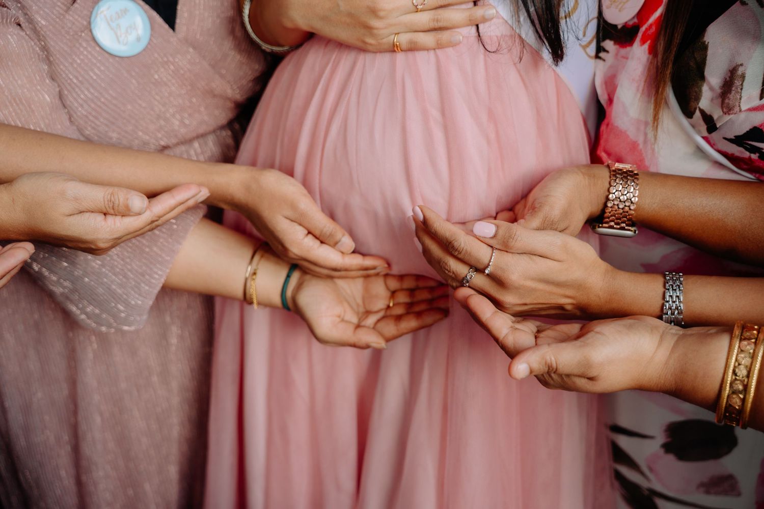 Multiple hands joining together in a circle showing unity and celebration.