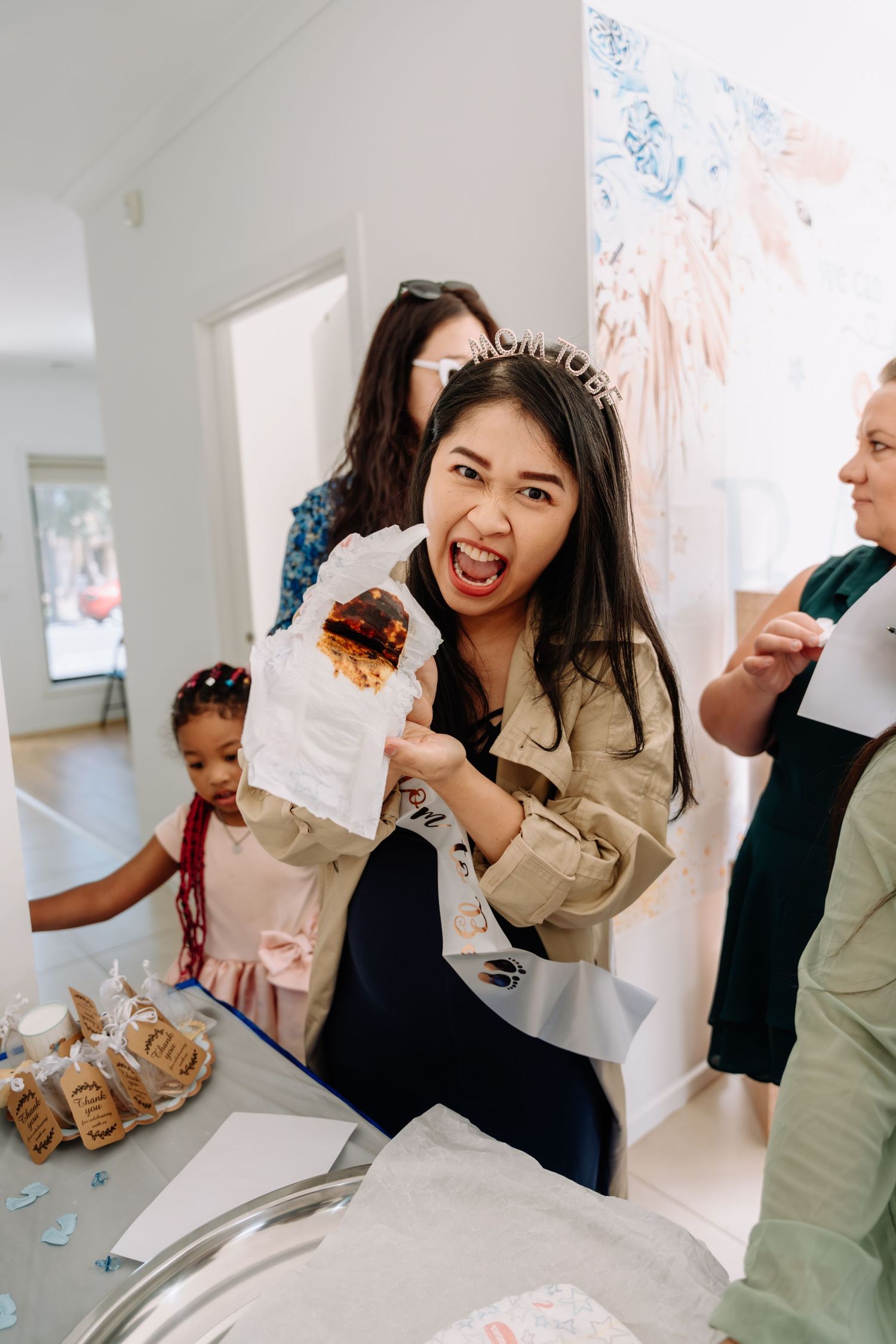 Party guest enjoying treats and snacks at a celebration with decorative backdrop.