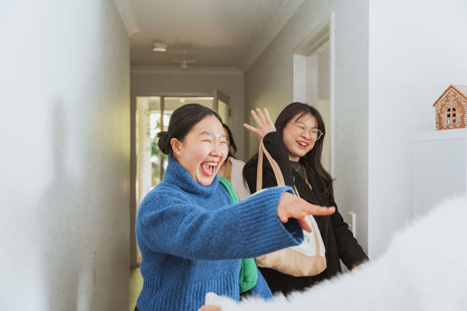 People in a hallway sharing joyful moments and embracing each other with laughter and smiles.