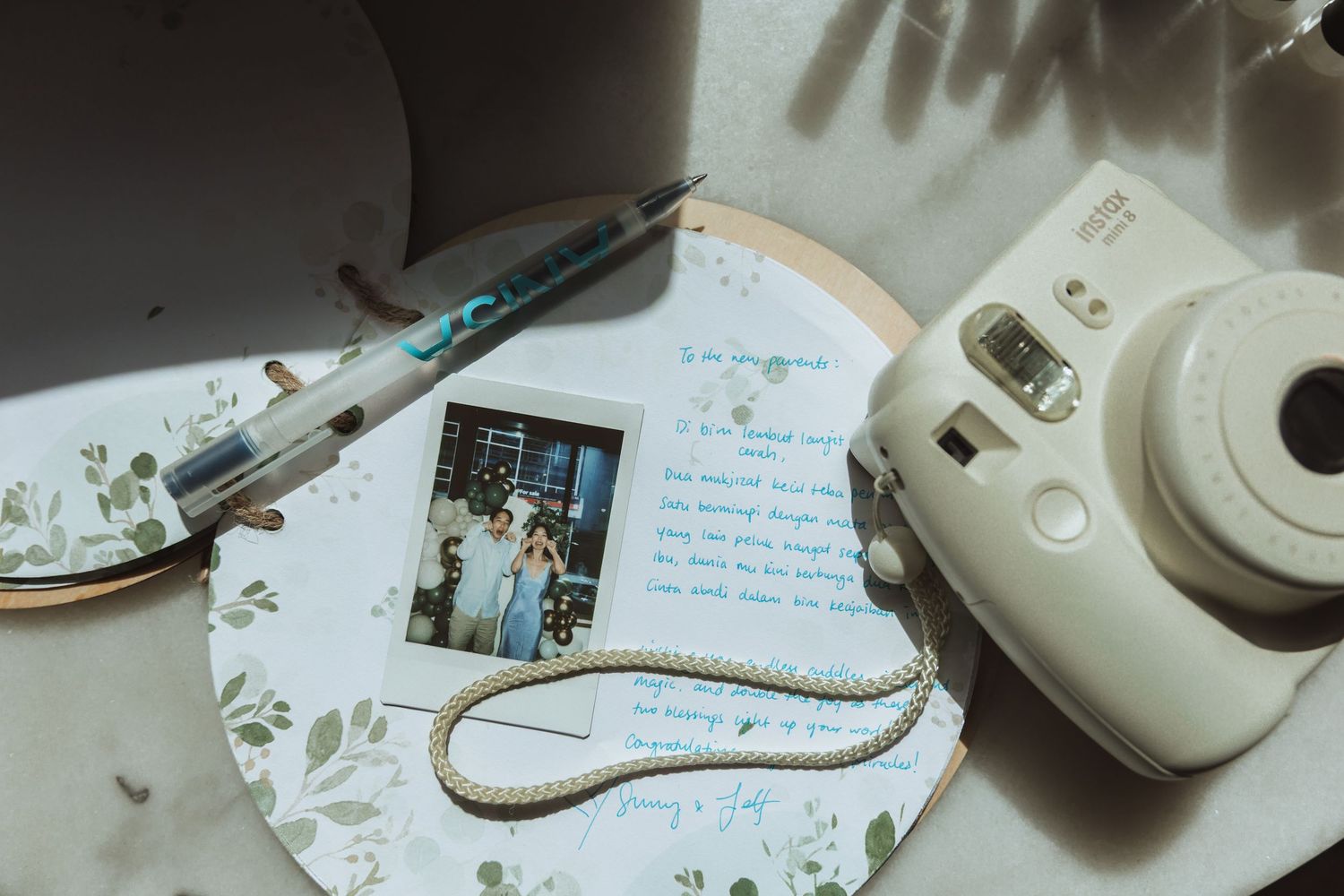 Wedding details including a white mouse computer, handwritten notes, and scattered decorative elements on a table.