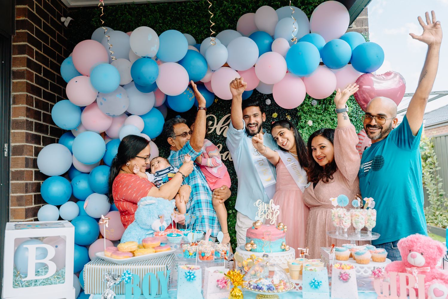 Elegant balloon garland in pink and blue shades decorates a gender reveal party setup.