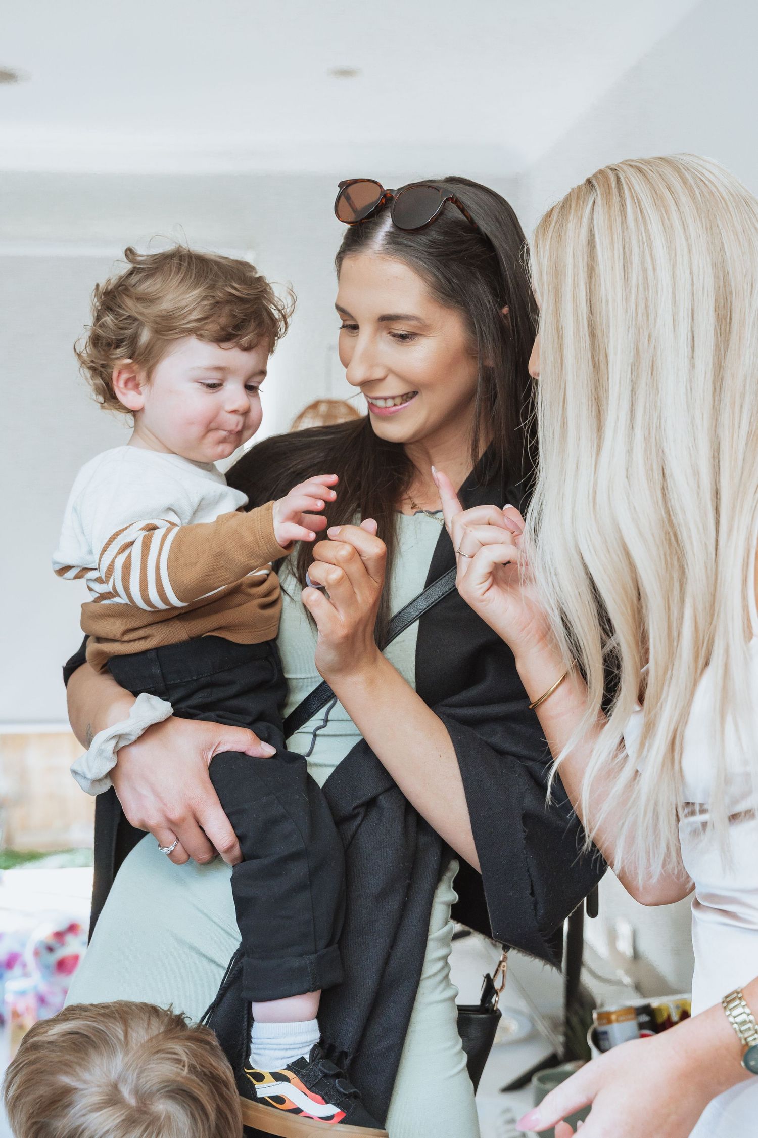 A heartwarming sequence of candid moments showing adults and a child sharing playful interactions in a bright interior setting.