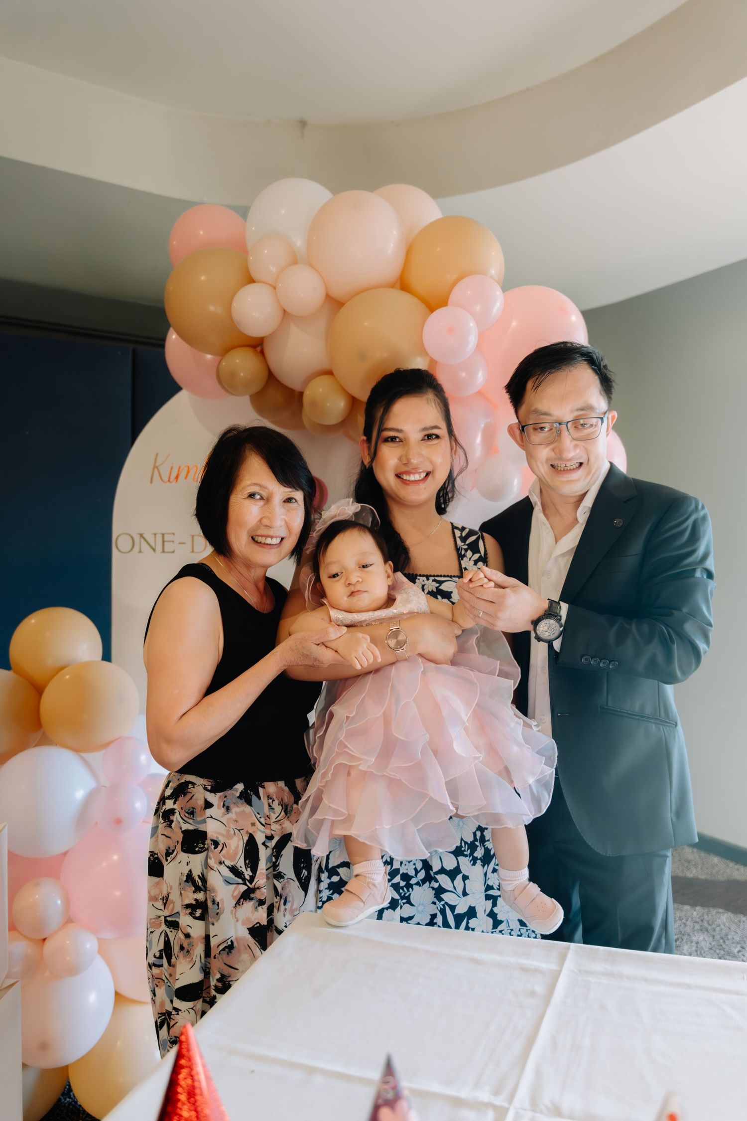 A festive celebration with pink and peach balloon decorations at a special event.