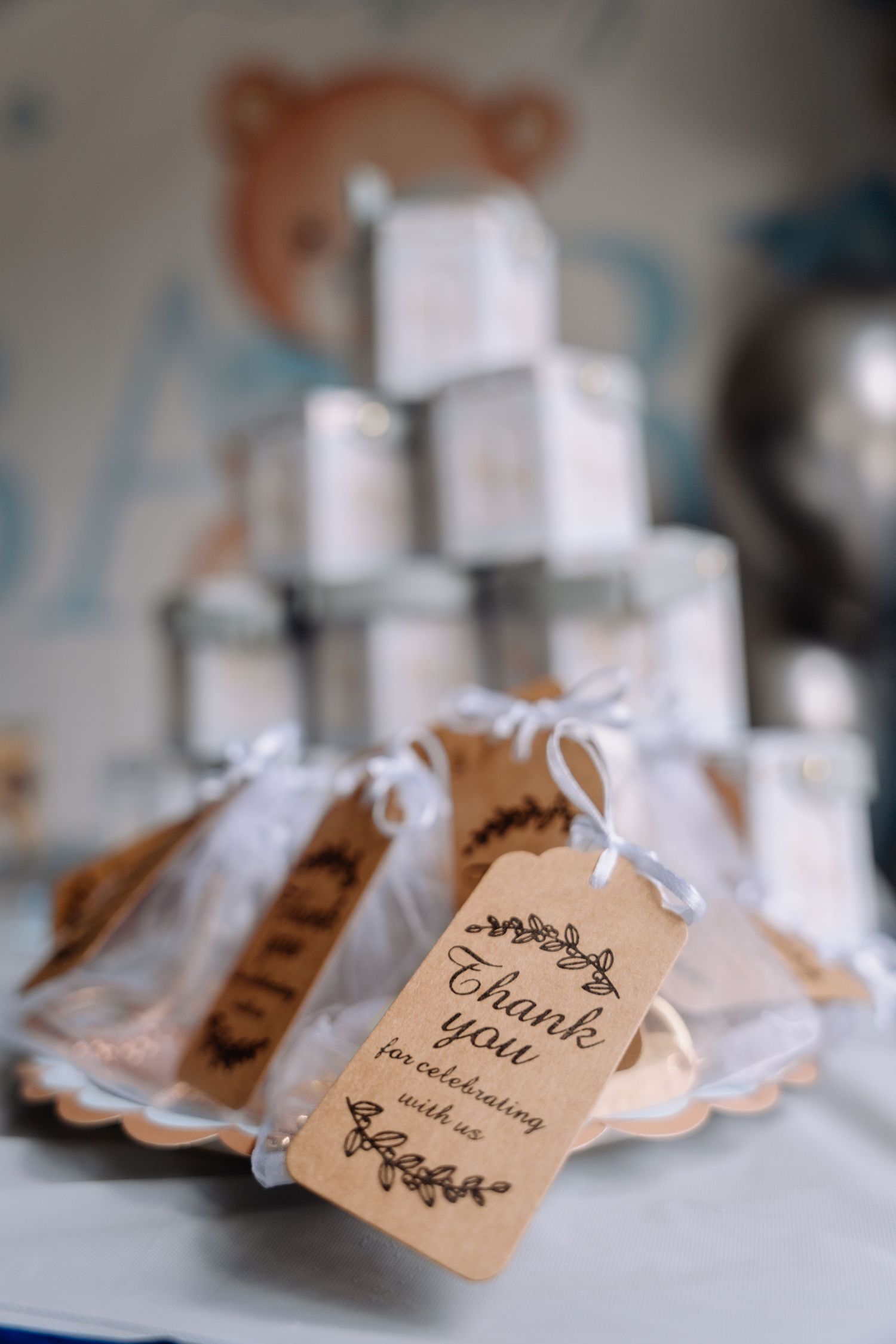 Row of vintage-style thank you tags with floral designs attached to small gift bags arranged in a line.