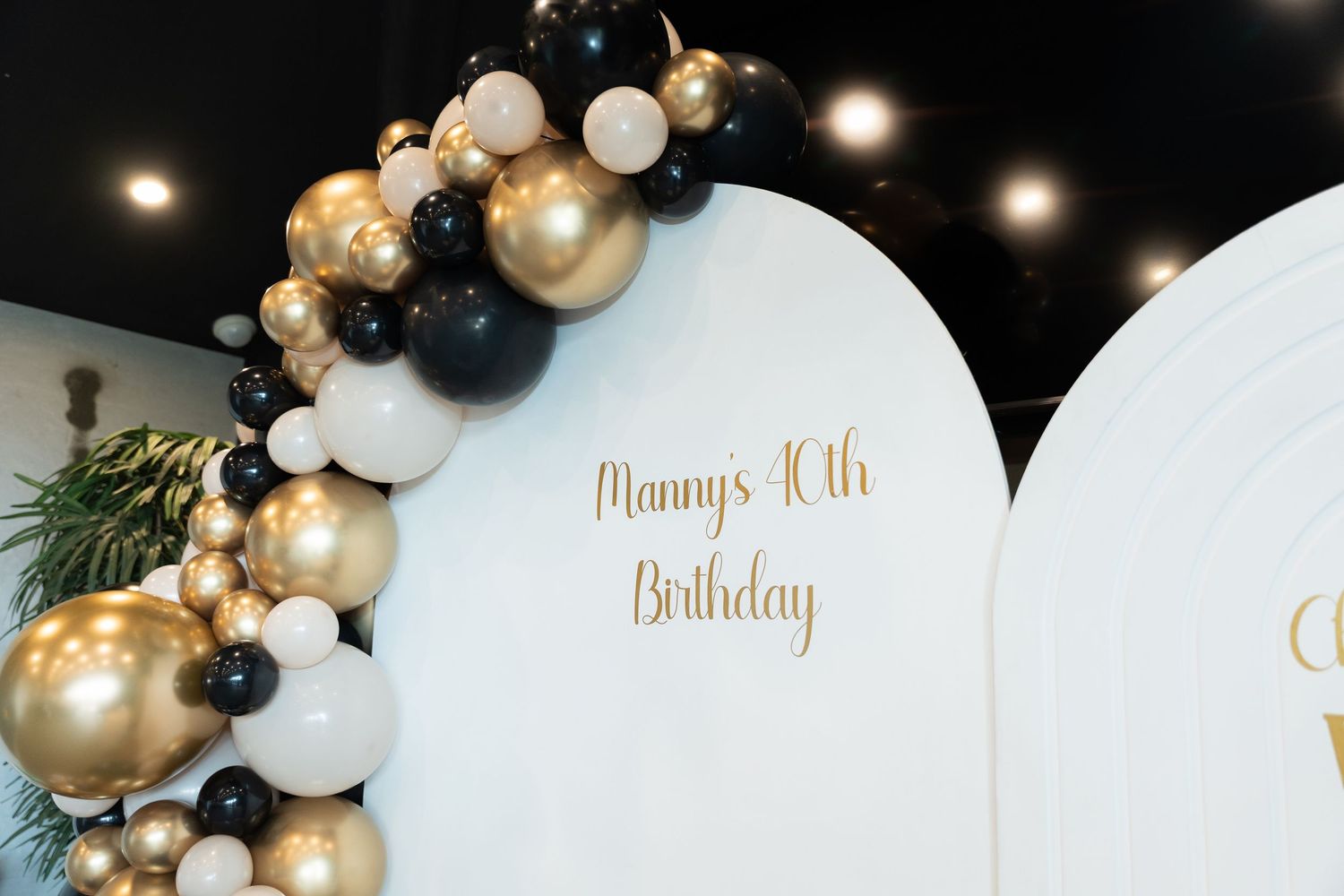 Elegant white backdrop with gold lettering and black and gold balloon arch for Mommy's 40th Birthday celebration.