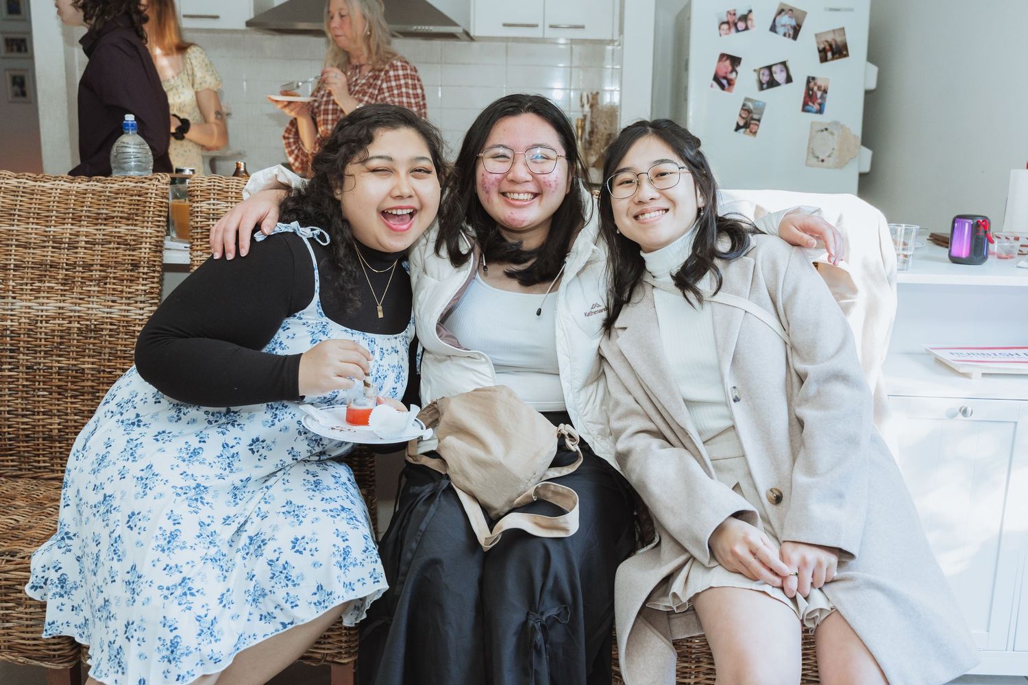 Group of friends in white winter coats gathered together and smiling.