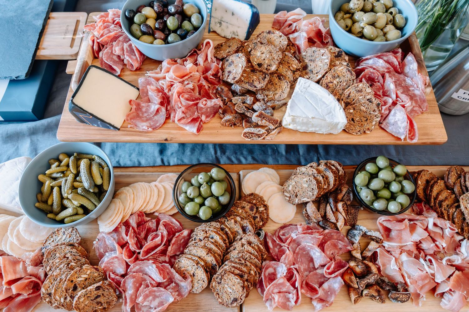 Charcuterie board with assorted meats, olives, and cheeses arranged on a wooden serving platter.