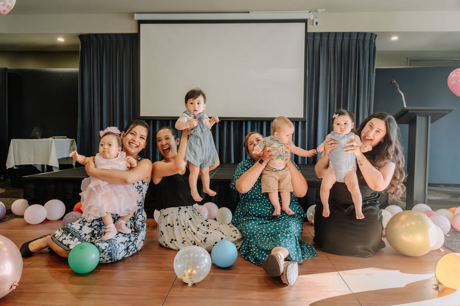 A group of people practicing yoga with colorful exercise balls in a modern studio space.