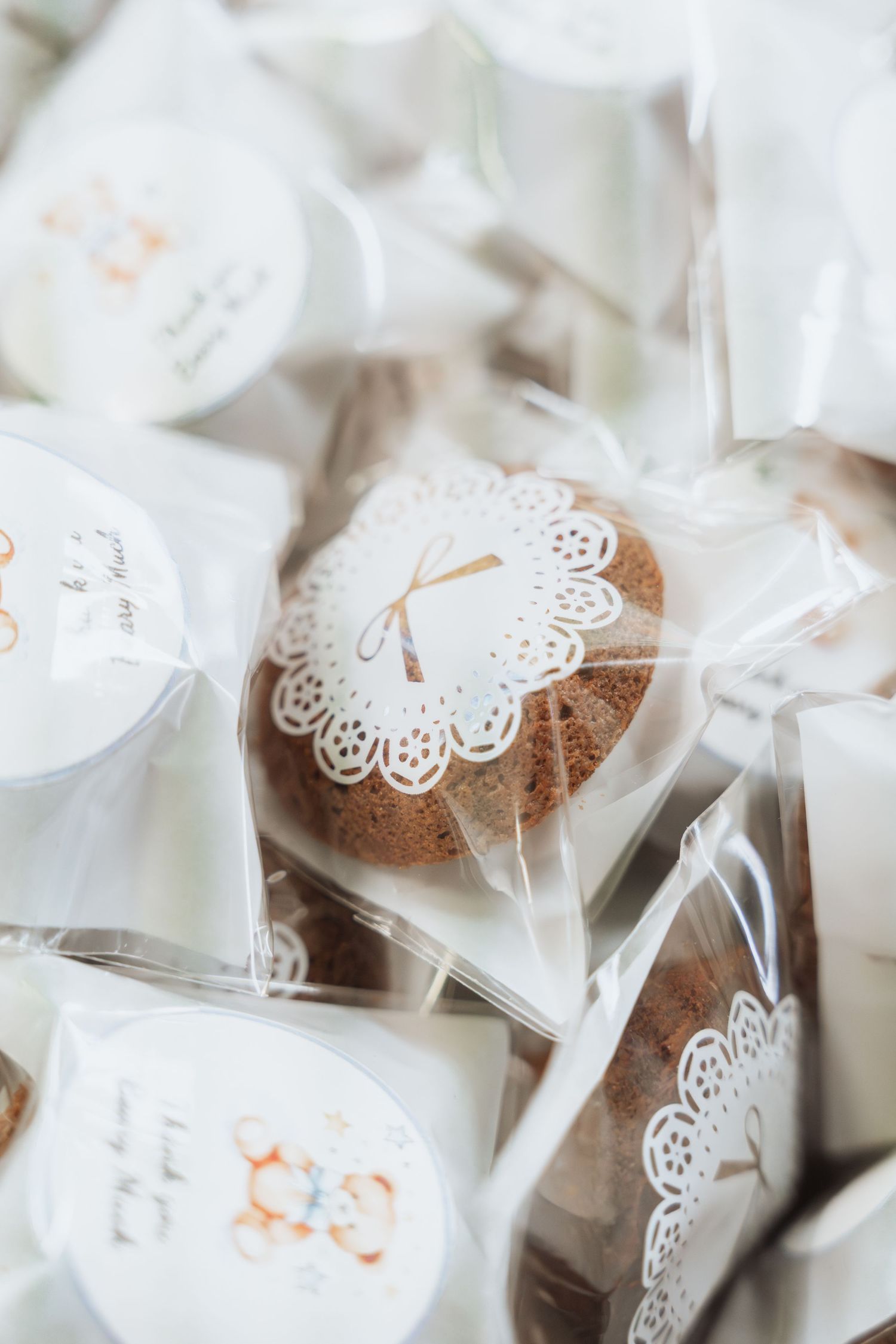 White wrapped party favors with delicate lace butterfly decorations arranged in neat rows.