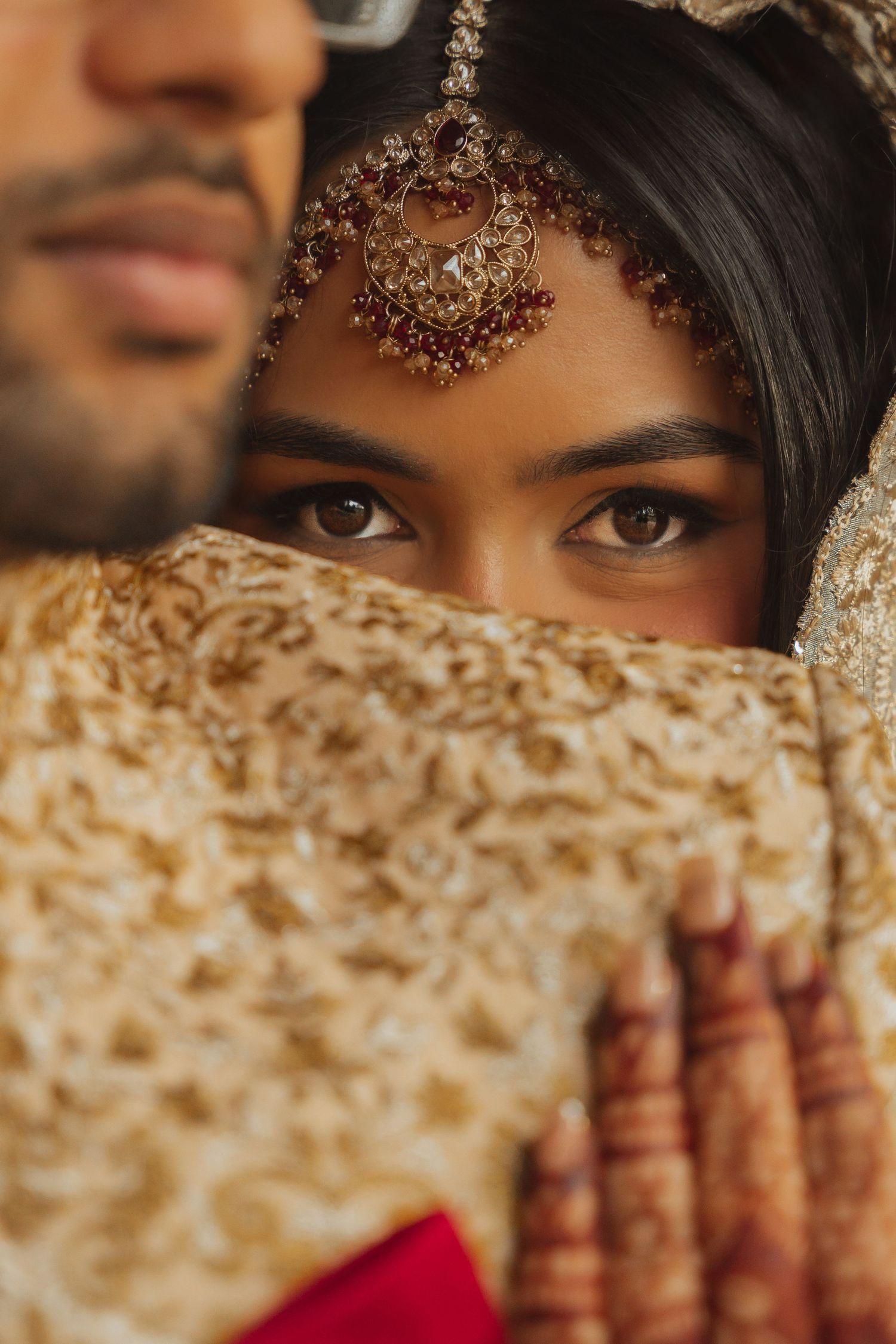 Traditional South Asian bridal eye makeup with ornate jewelry details.