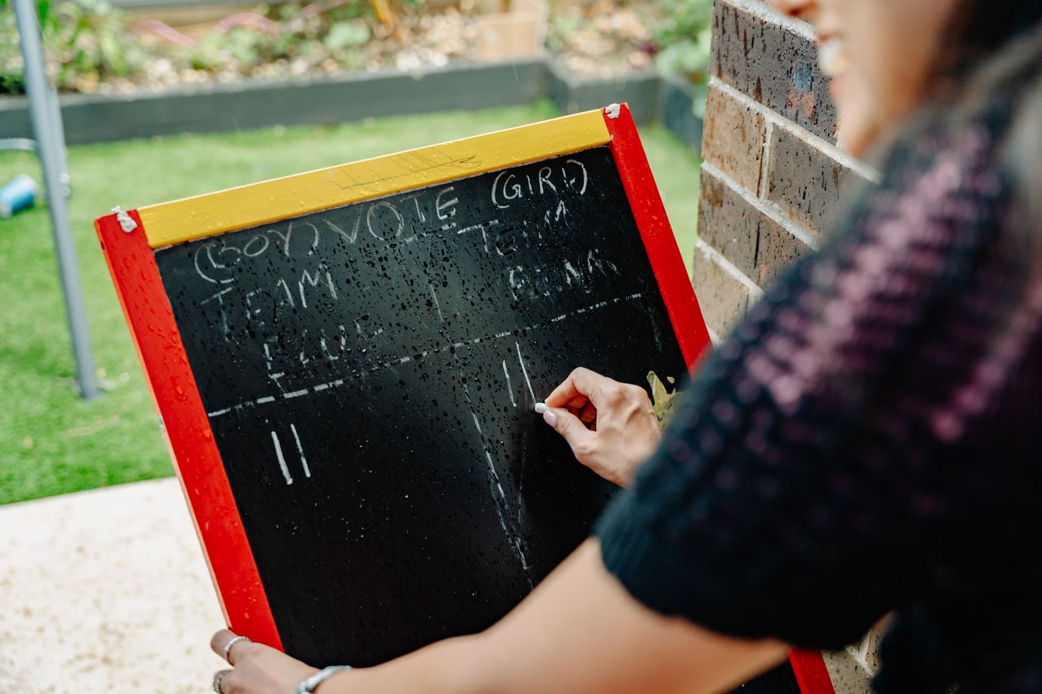 Small chalkboard signs being written on for a party celebration.