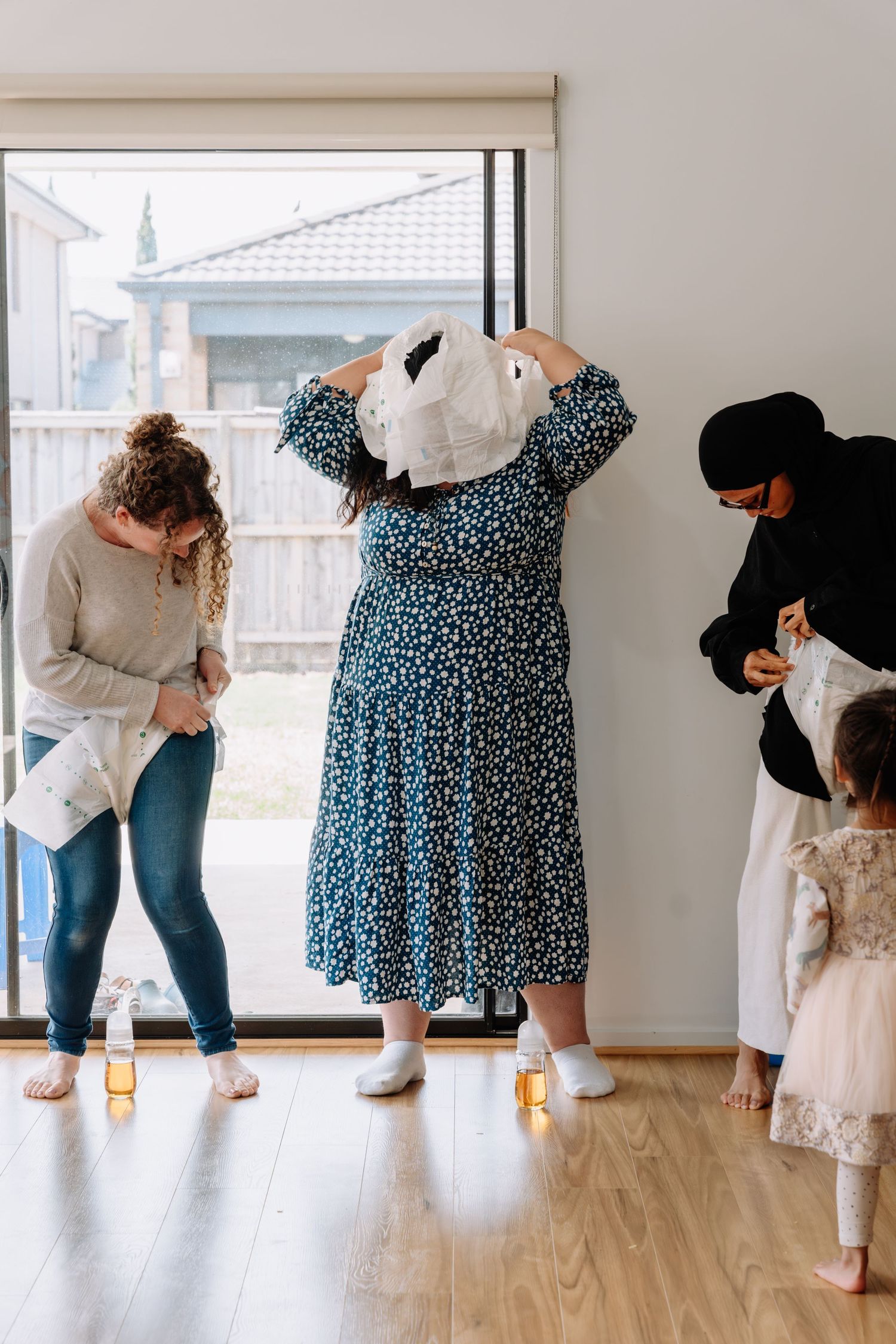 Sequence of photos showing legs and feet in jeans and dresses lined up against a white wall.