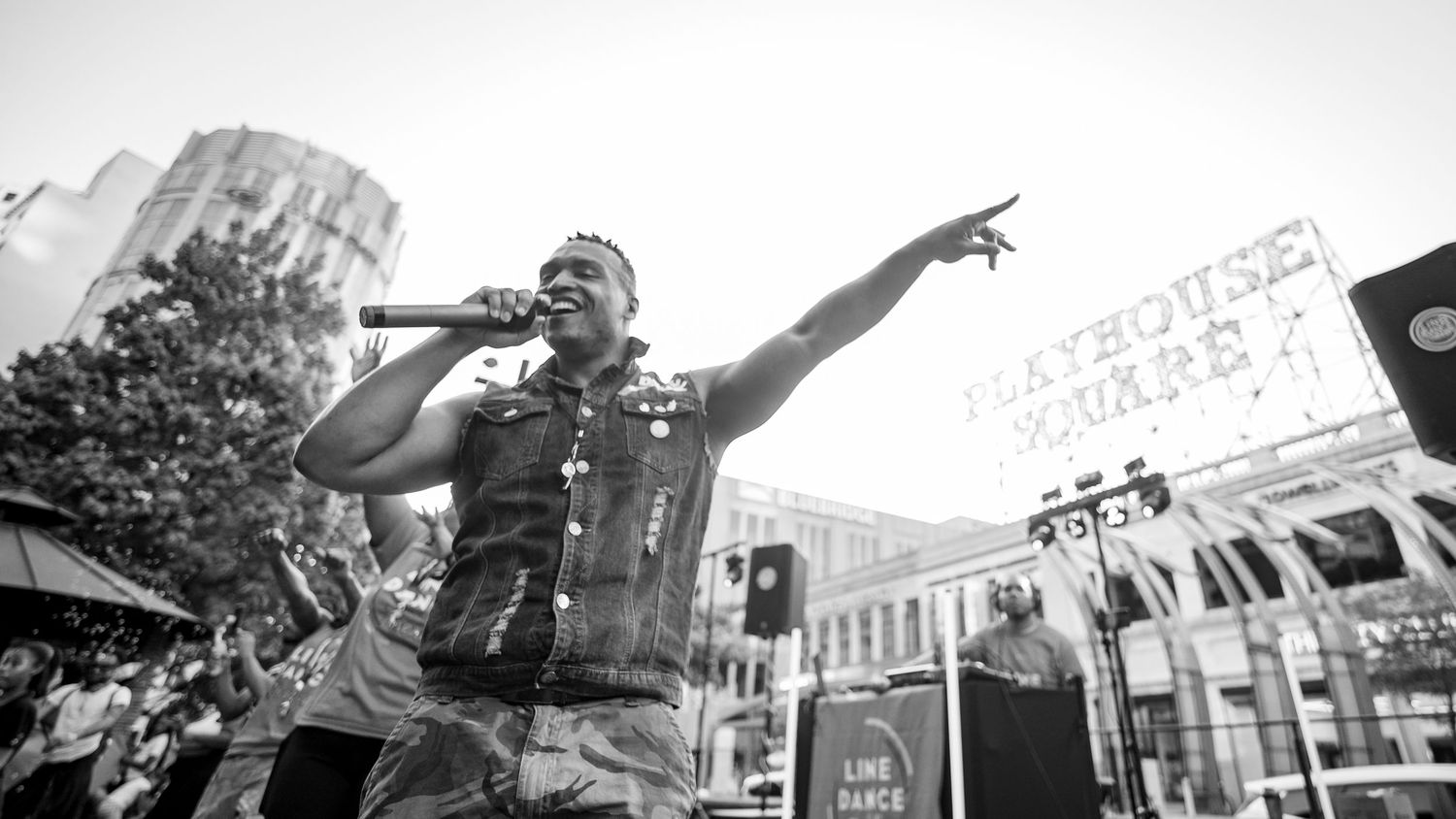 Black and white photo of a male rapper performing on stage at Playhouse Square outdoor concert.