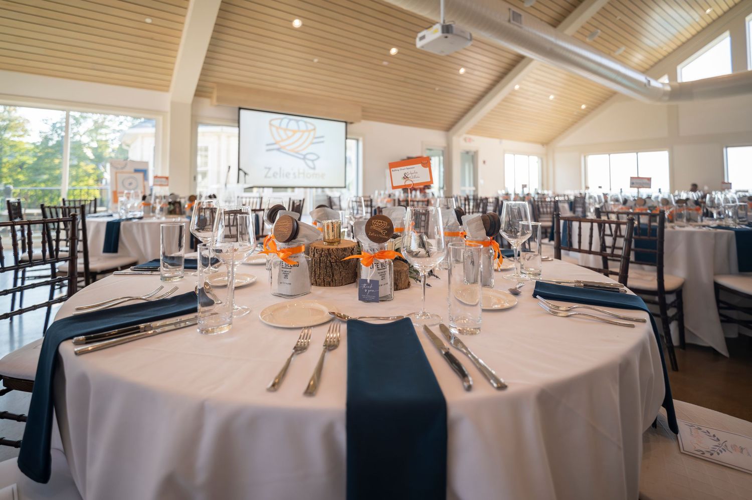 Close-up of elegant round table set with white linens and navy napkins for formal event.