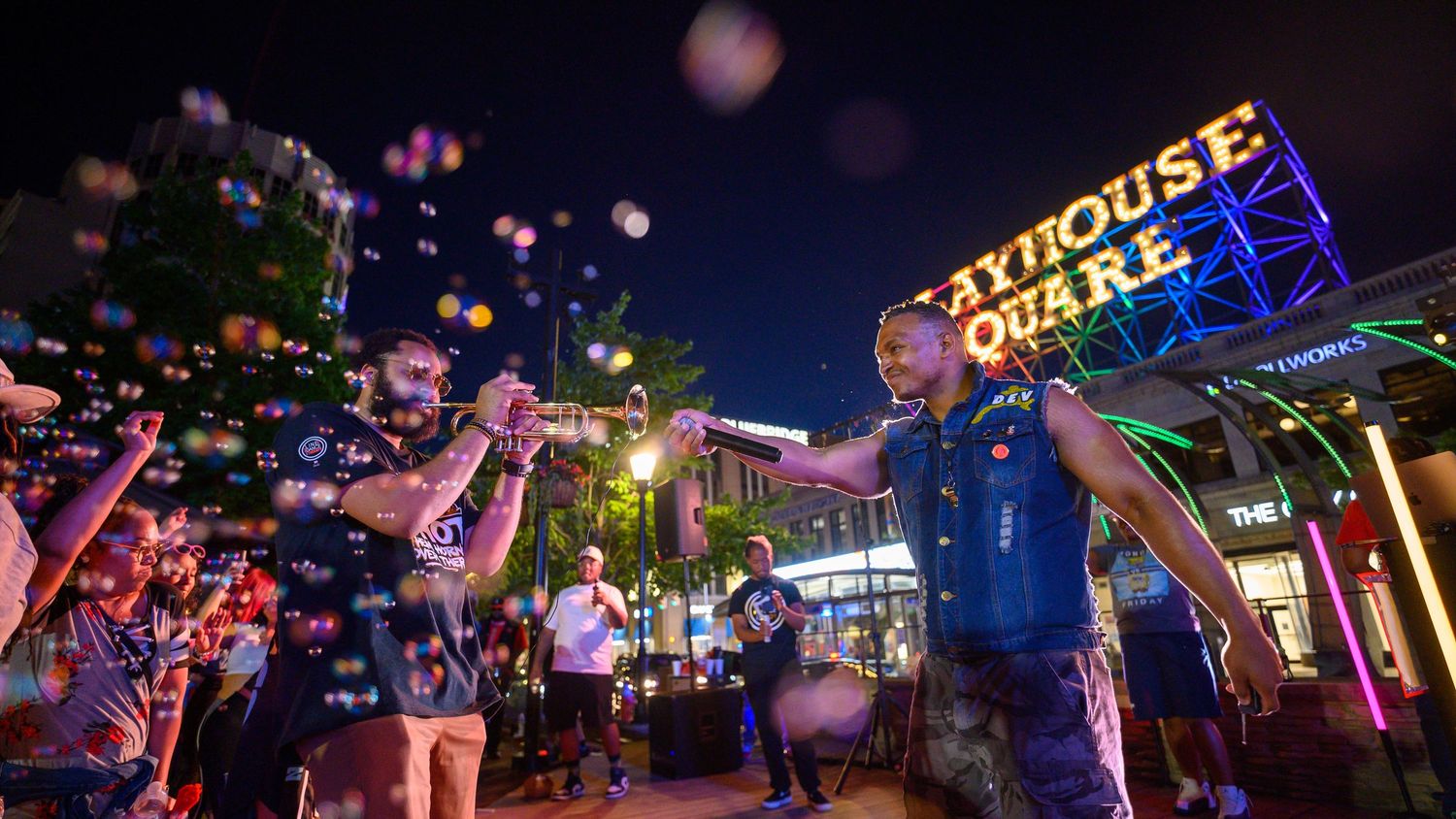 Lively nighttime street festival at Playhouse Square with performers, glowing bubbles, and crowds enjoying outdoor entertainment.