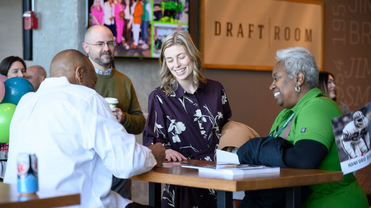 People gathered around registration table at Draft Room venue networking event.