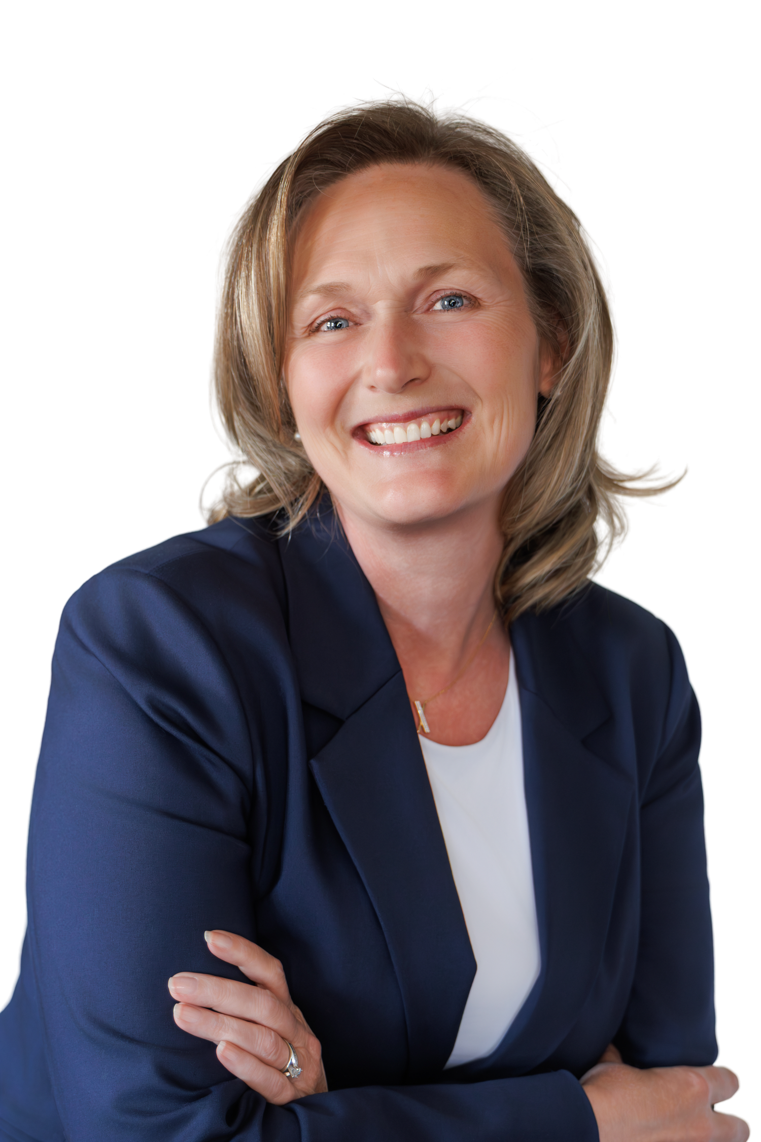 Professional woman in navy blazer with crossed arms smiling confidently against white background.